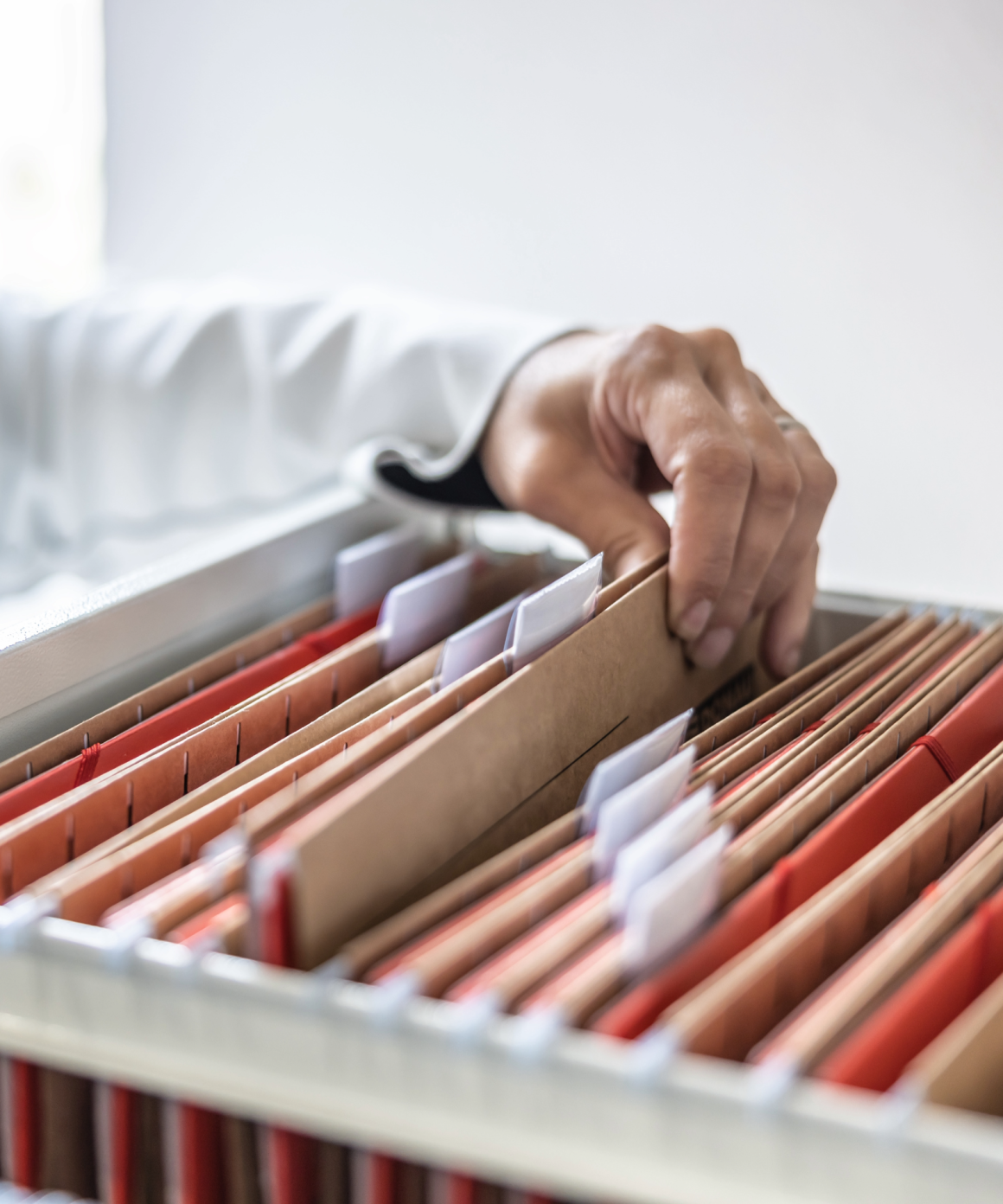 Person looking in a filing cabinet and pulling out a file